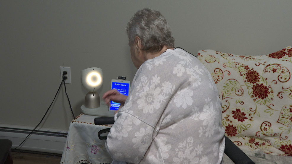 Elderly person interacting warmly with companion robot